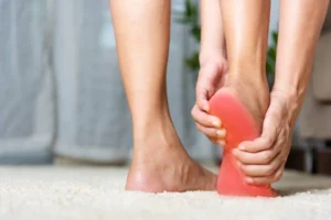 Person experiencing heel pain, a potential symptom of diabetic neuropathy.