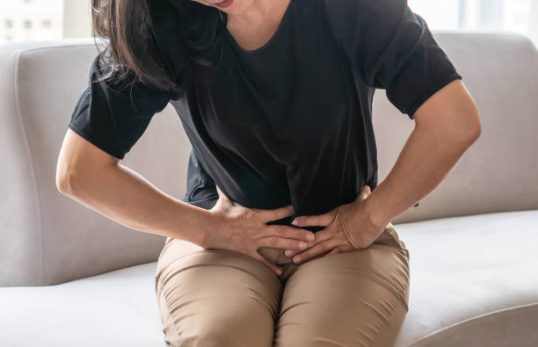 Abdominal pain in woman with stomachache illness from menstruation cramps, stomach cancer, irritable bowel syndrome, pelvic discomfort, Indigestion, Diarrhea or GERD (gastro-esophageal reflux disease)